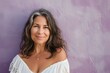 © CogniLens - Portrait of a satisfied woman in her 50s smiling at the camera in front of soft purple background