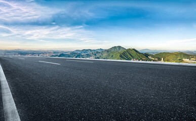 Wall Mural - Empty asphalt road and mountains under clear sky