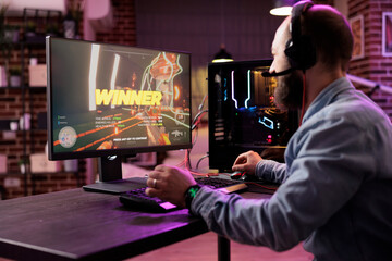 Canvas Print - Gamer winning intense singleplayer spaceship arcade racing videogame on powerful gaming computer system with neon lights. Man feeling relaxed after finally passing difficult game level