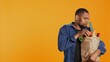 © DC Studio - Person counting all his freshly harvested produce in a paper bag, making sure he bought important ingredients for his vegan meals. Male model eating only ethically sourced food. Camera B.