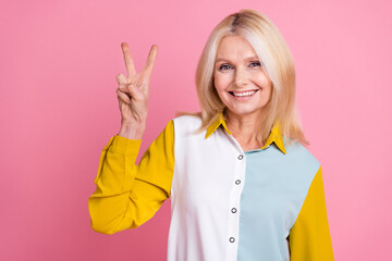 Poster - Portrait of elegant aged lady show v-sign wear shirt isolated on pink color background