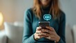 © May Chanikran - Woman using smartphone for messaging, illustrating modern communication, online chat, and digital interaction in a cozy indoor setting.
