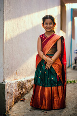 Portrait of a young Indian girl in traditional clothes standing in a street.