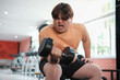 © ijeab - Overweight man grimacing while lifting dumbbell
