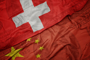 waving colorful flag of switzerland and national flag of china on the dollar money background. finance concept.