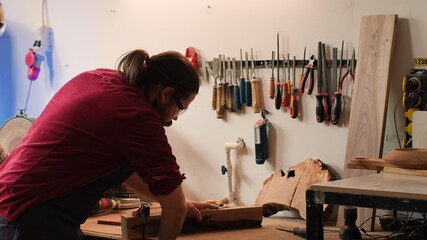 Sticker - Woodworker using bench vise to hold lumber block, starting furniture assembling in workshop. Craftsperson in joinery using vice tool to clamp piece of wood before carving it, camera A