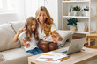 © SHOTPRIME STUDIO - Mother and daughter bonding on the couch while exploring a laptop together in a cozy living room setting