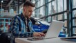 © ColdFire - Man working on laptop in car dealership showroom