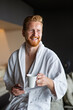 © NDABCREATIVITY - Handsome, muscular, young man drinking his morning coffee in a hotel room