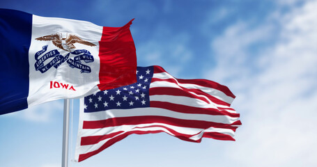 Wall Mural - Iowa state flag waving in the wind with the US flag on a clear day