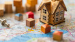© Welle Photos - wooden toy house and cubes on a real estate graph or map of land with a building plan, in the style of real estate concept