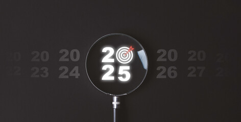 Wall Mural - 2025 and dartboard with arrow inside of magnifier glass on dark background for focus in new business objective target and goal when change in new year concept.