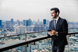 © Jack Tamrong - Smart and handsome businessman standing at balcony with cityscape background