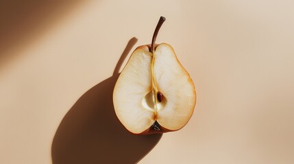 Wall Mural - Sliced pear on light beige background, high contrast still life shot. Minimalist food photography concept