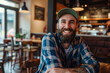 © frankb - Bearded man sitting in a cozy cafe, smiling at the camera
