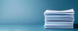 © CALMANDRELAX STUDIO - Stack of white papers organized on a blue background, representing office documentation, business, and information organization.