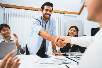 Wall Mural - Diverse group of office employee worker shake hand after making agreement on strategic business marketing meeting. Teamwork and positive attitude create productive and supportive workplace. Prudent
