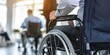 © kiimoshi - A person in a wheelchair is sitting in a waiting room.