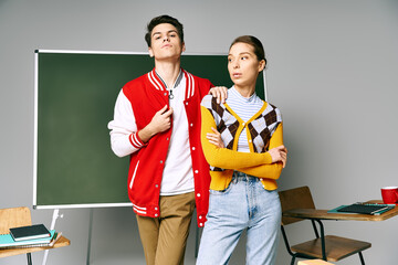 Wall Mural - Two young people in casual attire stand confidently in front of a chalkboard in a college classroom.