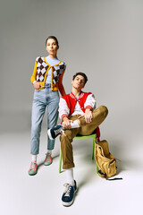 Wall Mural - A male and female students stylishly pose on a vintage chair in a college classroom.