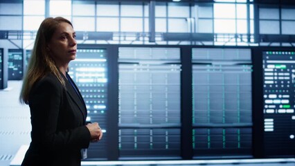 Poster - engineer inspecting server room hardware, walking between supercomputers. it professional supervisin