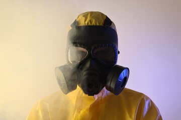 Wall Mural - Worker wearing gas mask in color lights and smoke