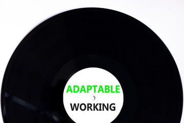 Adaptable working symbol. Concept words Adaptable working on beautiful white black vinyl disk. Beautiful white paper background. Business Adaptable working concept. Copy space.