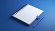 © BozStock - Blue notebook with a pen on a blue background. The notebook is open and has blank pages. The pen is blue and has a silver tip.