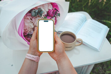 Canvas Print - Phone with isolated screen on the background of a book, a cup of tea and a bouquet