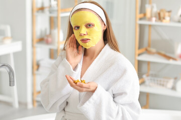 Poster - Young woman with turmeric mask and roots in bathroom