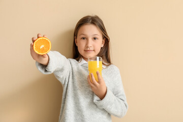 Canvas Print - Cute little girl with glass of juice and orange on beige background