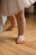 © Leka - Baby  barefoot standing on wooden  floor