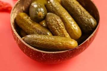 Wall Mural - Bowl with delicious fermented cucumbers on red background, closeup