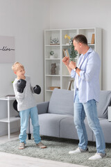 Wall Mural - Mature doctor with his little son boxing at home
