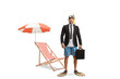 © Ljupco Smokovski - Businessman with snorkelling fins and mask holding a briefcase and standing next to a beach chair