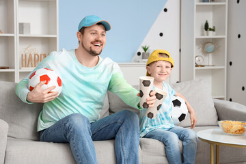 Poster - Young father and little son watching football at home
