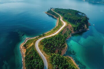 Wall Mural - An aerial shot captures a winding road on a narrow land strip amidst the blue sea, highlighting nature's beauty