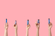 © Pixel-Shot - Many hands holding electronic cigarettes on pink background