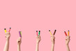 © Pixel-Shot - Many hands holding electronic cigarettes on pink background