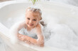 © Pixel-Shot - Cute little girl with foam and soap bubbles taking bath in bathroom