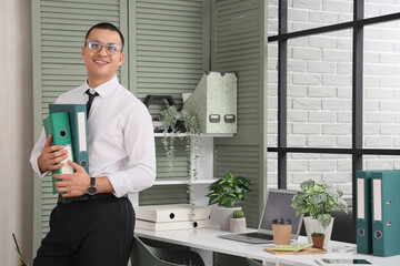 Wall Mural - Handsome businessman with folders in office