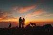 © LifeMedia - Silhouettes of people and a dog on a mountain top at sunset under a cloudy sky
