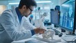 © Summit Art Creations - A white-collar worker in a lab coat gestures while holding a knee joint model in front of a computer screen. AIG41