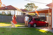 © Austockphoto - Aussie family packing car with luggage for weekend away holiday
