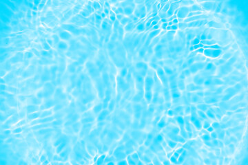 Blue water with ripples on the surface. Defocus blurred transparent blue colored clear calm water surface texture with splashes and bubbles. Water waves with shining pattern texture background.