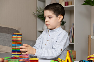 a six-year-old boy plays with a magnetic construction set. toys for children to develop imagination.