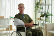 © DragonImages - Portrait of man in camouflage uniform having wound in his arm sitting in wheelchair