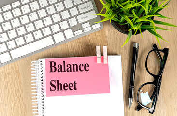 Poster - BALANCE SHEET text pink sticky on notebook with keyboard, pen and glasses