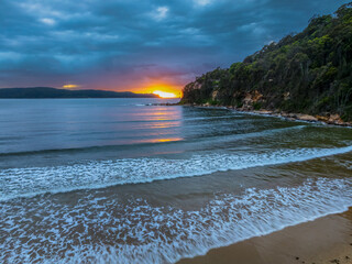 Wall Mural - Sunrise seascape with rain clouds and flat surf