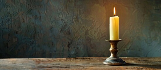 Poster - Burning candle in candlestick on table. with copy space image. Place for adding text or design